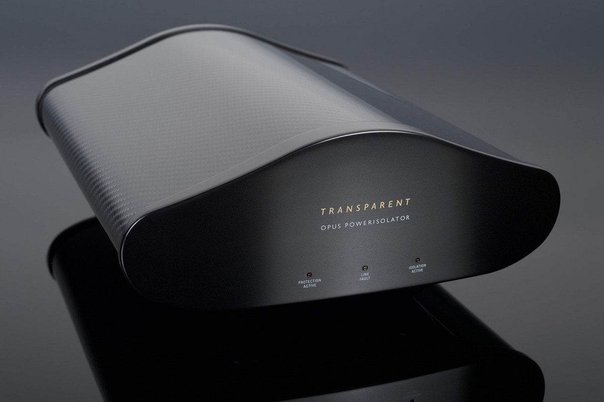 A sleek, black Transparent Audio OPUS PowerIsolator Generation 5 device, featuring indicator lights for protection active, line fault, and ground fault, rests on a reflective surface, ensuring noise-free power.